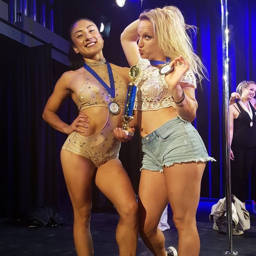 Amanda holding a competition trophy on stage
