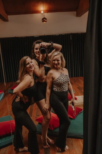 Three women posing together with a camera after a retreat session